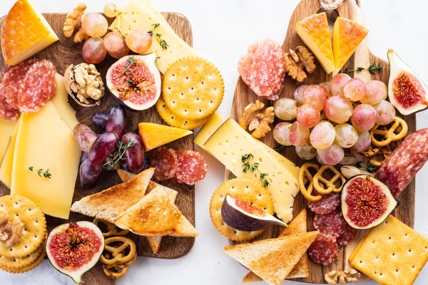 Prato de queijo servido com uvas, geléia, figos, biscoitos finos e nozes em um fundo . — Fotografia de Stock