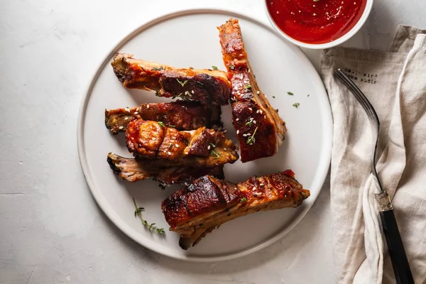 Costelas de porco Bbq com molho de pimenta no prato branco. Costeletas de porco no fundo da ardósia. Espaço de cópia . — Fotografia de Stock