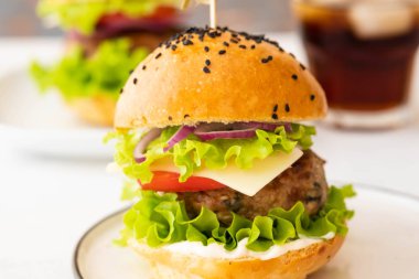 Sığır eti, domates, peynir, patates kızartması, marul ile lezzetli hamburger. Kopya alanı.