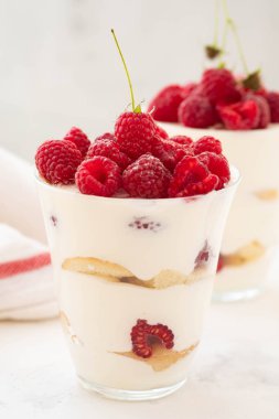 Ahududu tatlı, cheesecake, ahududulu tiramisu, önemsememek, mus bir bardak beyaz bir arka plan üzerinde.