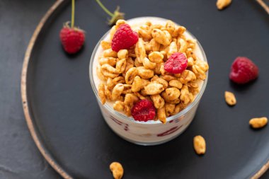 Granola yoğurt ve üst görünümden siyah arka plan üzerine taze çilek ile kase. Sağlıklı kahvaltı. Kopya alanı.