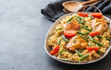 Bulgur, fasulye kuşkonmaz ve domates ile ızgara tavuk uyluk. Lezzetli yemegi.