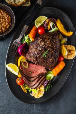 Biber sosu ve koyu ahşap arka plan üzerinde ızgara sebze sığır eti biftek kulübü. ROAS sığır eti. Kopya alanı.