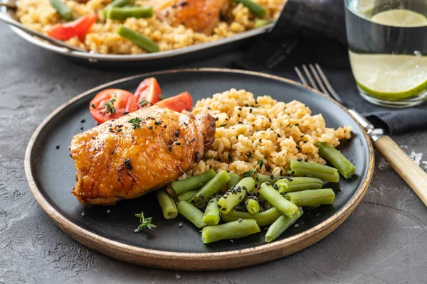 Bulgur, fasulye kuşkonmaz ve domates ile ızgara tavuk uyluk. Lezzetli yemek. Kopya alanı.