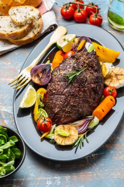 Biber sosu ve koyu ahşap arka plan üzerinde ızgara sebze sığır eti biftek kulübü. ROAS sığır eti. Kopya alanı.