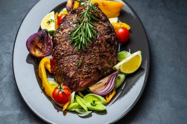 Biber sosu ve koyu ahşap arka plan üzerinde ızgara sebze sığır eti biftek kulübü. ROAS sığır eti. Kopya alanı.