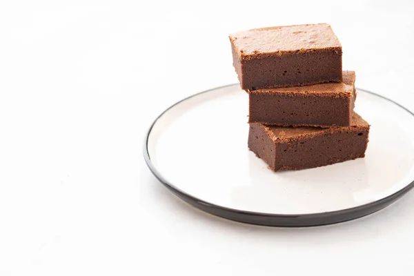 Chocolate brownie piezas cuadradas en la pila en el plato blanco. Postre americano tradicional delicioso. Copiar espacio . — Foto de Stock