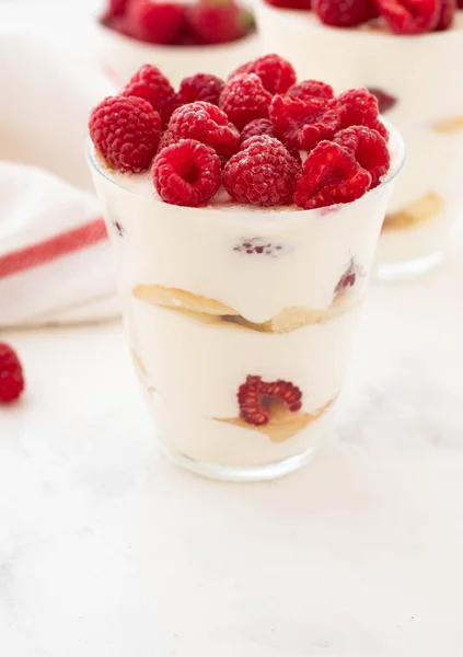 Postre de frambuesa, tarta de queso, tiramisú de frambuesa, bagatela, mousse en un vaso sobre un fondo blanco . — Foto de Stock