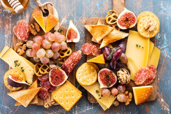 Prato de queijo servido com uvas, geléia, figos, biscoitos finos e nozes em um fundo . — Fotografia de Stock