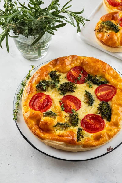 Plantaardige taart quiche met broccoli, tomaten en zachte kaas op witte achtergrond. — Stockfoto