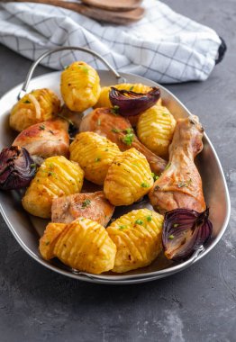 Patates kimyon ve siyah arka plan üzerine sarımsak ile kavrulmuş tavuk budu. Kopya alanı.