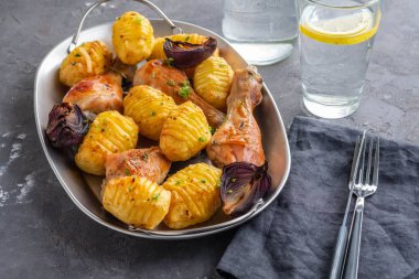 Patates kimyon ve siyah arka plan üzerine sarımsak ile kavrulmuş tavuk budu. Kopya alanı.