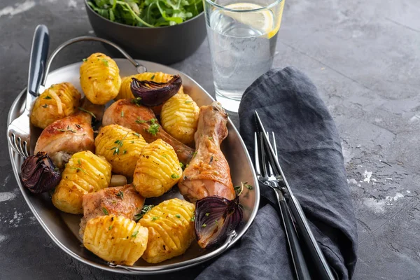 Patates kimyon ve siyah arka plan üzerine sarımsak ile kavrulmuş tavuk budu. Kopya alanı.