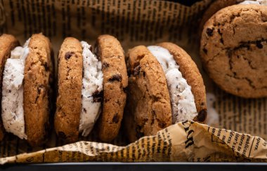 Kağıt arka plan üzerinde dondurma sandviç çikolatalı kurabiye ek yük vurdu.