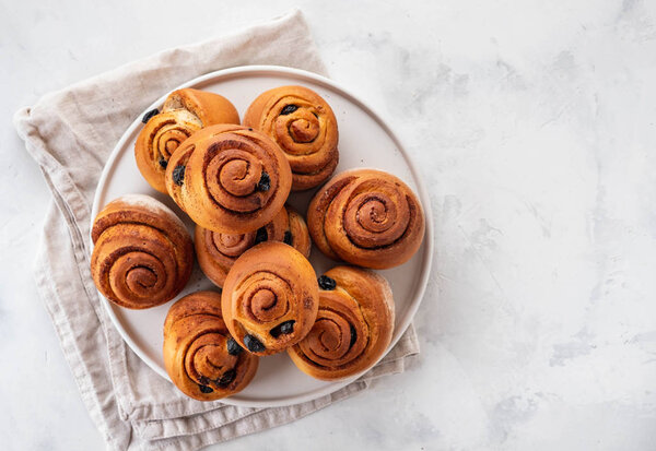 Freshly Baked Traditional Sweet Cinnamon Rolls, Swirl on white plate. Copy space.
