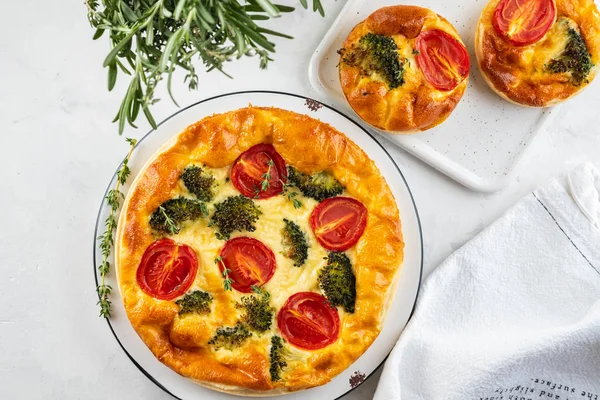Plantaardige taart quiche met broccoli, tomaten en zachte kaas op witte achtergrond. — Stockfoto