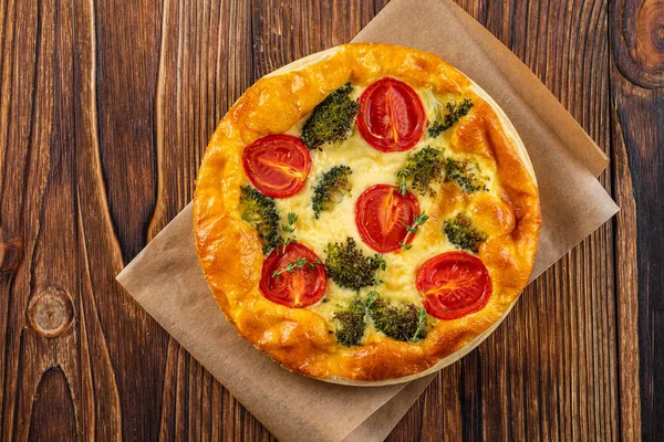 Groenten taart met broccoli, erwten, tijm. tomaten en kaas op houten achtergrond. Kopiëren van ruimte. — Stockfoto