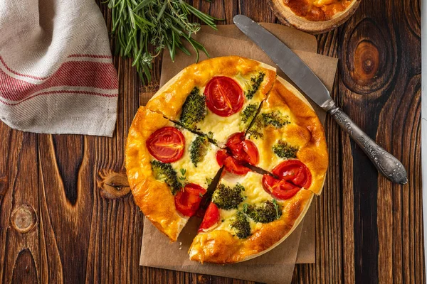 Groenten taart met broccoli, erwten, tijm. tomaten en kaas op houten achtergrond. Kopiëren van ruimte. — Stockfoto