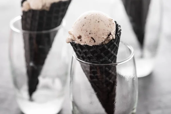 Černý kužel, vafle pohár se zmrzlinou, zmrzlina v černém kužele a sklo. — Stock fotografie