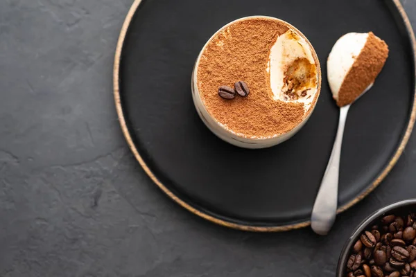 Lezzetli İtalyan tatlı tiramisu, çikolata, kakao ve kahve fasulye siyah bir arka plan. Kopya alanı ile üstten görünüm.