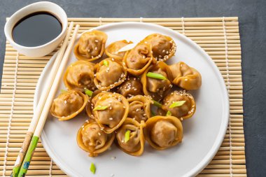 Ev geleneksel vapur ve dekore edilmiş soya sosu, maydanoz, giner bambu hasır üzerinde hizmet Çince ve Korece köfte yapımı.