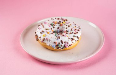 Pastel pembe arka plan üzerine krema ile çörek. Tatlı çörek. Kopya alanı.