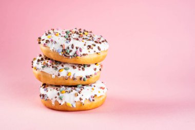 Pastel pembe arka plan üzerine krema ile çörek. Tatlı çörek. Kopya alanı.