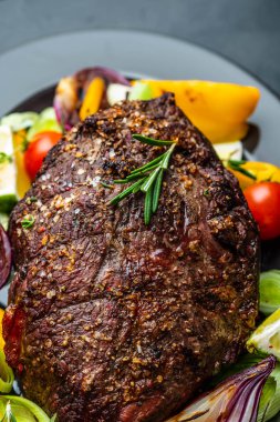 Biber sosu ve koyu ahşap arka plan üzerinde ızgara sebze sığır eti biftek kulübü. ROAS sığır eti. Kopya alanı.