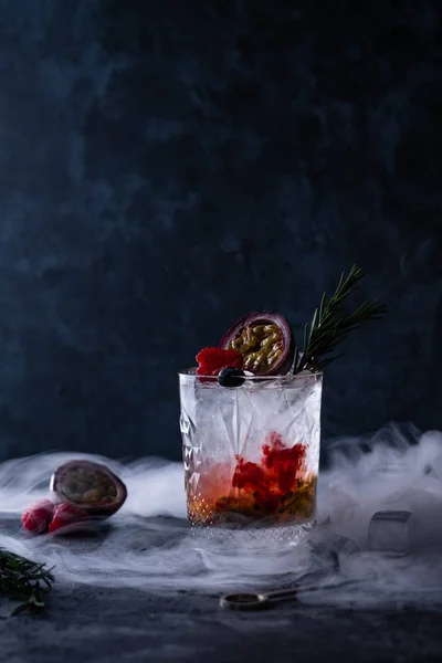 Rinfrescante con un bicchiere di cocktail al frutto della passione su sfondo nero . — Foto Stock