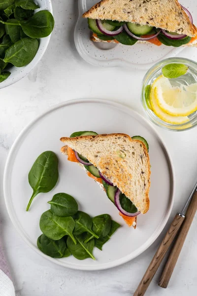 Sandwiches with cream cheese, salmon and spinach on a white backround. — Stock Photo, Image