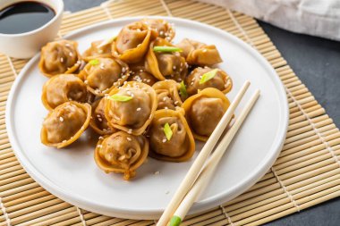 Ev geleneksel vapur ve dekore edilmiş soya sosu, maydanoz, giner bambu hasır üzerinde hizmet Çince ve Korece köfte yapımı.