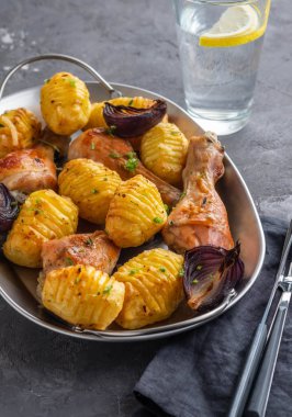 Patates kimyon ve siyah arka plan üzerine sarımsak ile kavrulmuş tavuk budu. Kopya alanı.