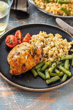 Bulgur, fasulye kuşkonmaz ve domates ile ızgara tavuk uyluk. Lezzetli yemek. Kopya alanı.