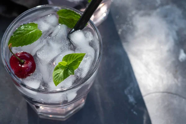 Cocktail de cereja fresco. Cocktail fresco de verão com cubos de cereja e gelo. Copo de bebida de refrigerante de cereja no fundo de pedra escura . — Fotografia de Stock