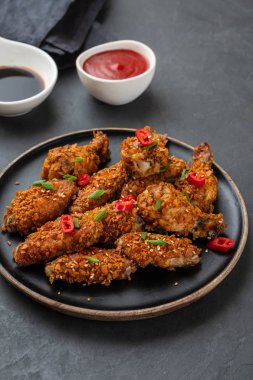 Tavuk kanadı sosu ve karanlık bir arka plan üzerine biber ile. Kopya alanı.