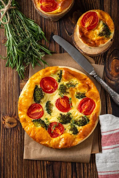 Groenten taart met broccoli, erwten, tijm. tomaten en kaas op houten achtergrond. Kopiëren van ruimte. — Stockfoto