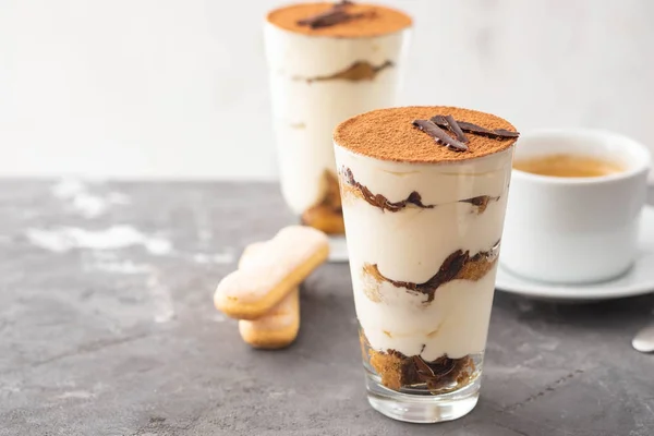 Tiramisú en un vaso con granos de café sobre fondo gris. Copiar espacio. Enfoque selectivo . —  Fotos de Stock