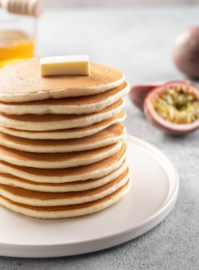 Krep ler tereyağı ve bal ile yığını. Gri arka kaunt.