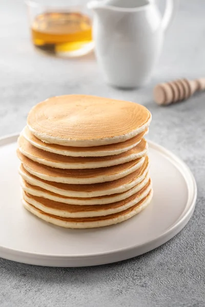 Pannkakor stack med smör och honung. Grå bakrund. — Stockfoto