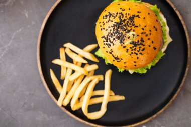 Taze ev yapımı Hamburger patates kızartması patates ile plaka siyah susam ile. Üstten görünüm. Kopya alanı.