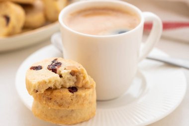 Bir fincan kahve ile beyaz bir arka plan üzerinde ev yapımı kurabiye.