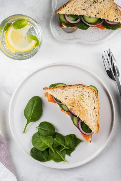 Sandwiches with cream cheese, salmon and spinach on a white backround. — Stock Photo, Image