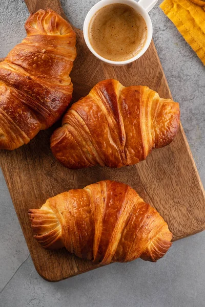 Café da manhã com croissants, tábua de corte e café preto. Deitado plano, vista superior . — Fotografia de Stock