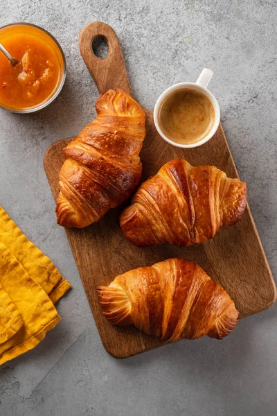 Café da manhã com croissants, tábua de corte e café preto. Deitado plano, vista superior . — Fotografia de Stock