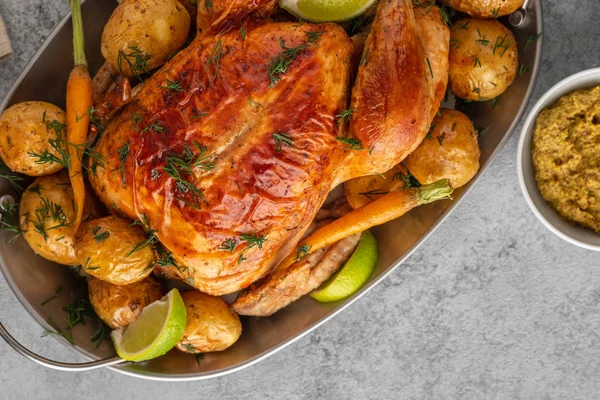 Κοτόπουλο ψημένο με πατάτες, λάιμ και βότανα σε γκρι τηγάνι. Κορυφαία προβολή. — Φωτογραφία Αρχείου