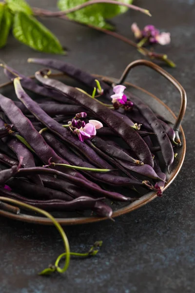 Fresh purple string beans on a black table, clean eating,selective focus.