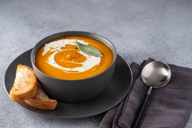 Gri taş arka plan üzerinde krema ile kabak çorbası. Kopyalama alanı.