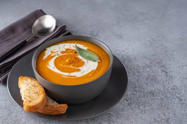 Gri taş arka plan üzerinde krema ile kabak çorbası. Kopyalama alanı.