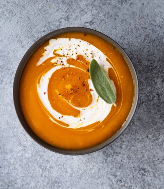 Gri arka planda adaçayı ile kabak çorbası. Üstte görüntü.