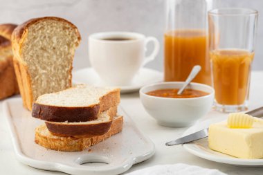 Taze brioche ekmek ve tereyağı, meyve suyu ve reçel. Kıta kahvaltısı.